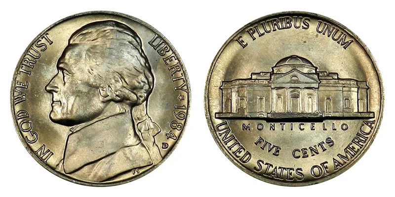 Group of 1984 Jefferson nickels from Philadelphia and Denver mints arranged on a flat surface showing variety of conditions