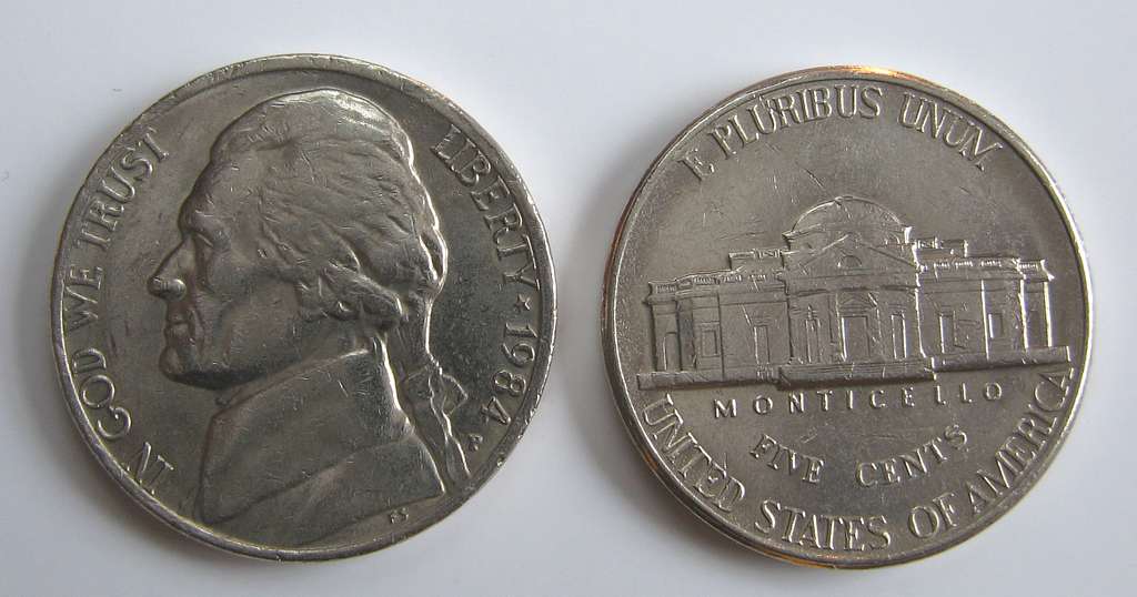 Grading strip showing four 1984 Jefferson nickels in worn, circulated, uncirculated, and gem uncirculated condition side by side